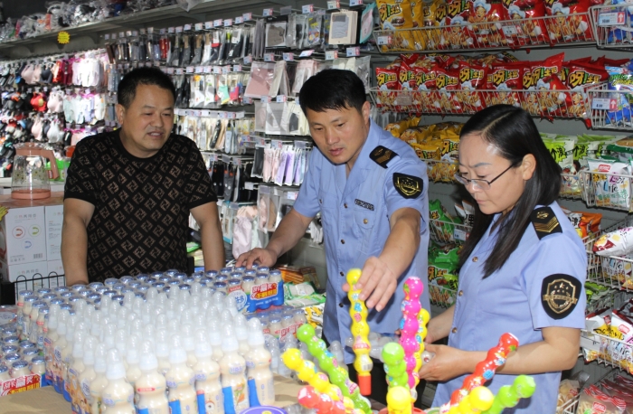 图为该局执法人员在一家超市检查儿童食品质量。