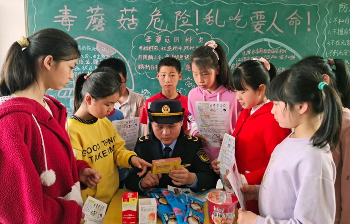 图为该县市场监管局岭背分局工作人员在岭背大窝小学向学生讲解如何鉴别假冒伪劣食品药品。王雨林 段丁长 摄