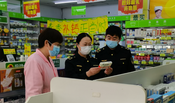 图为监管人员检查门店药品销售登记情况。