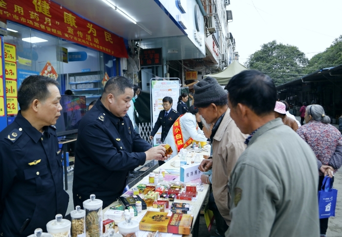 市场监管部门工作人员向公众介绍如何识别假冒伪劣药品。（何正君 摄）